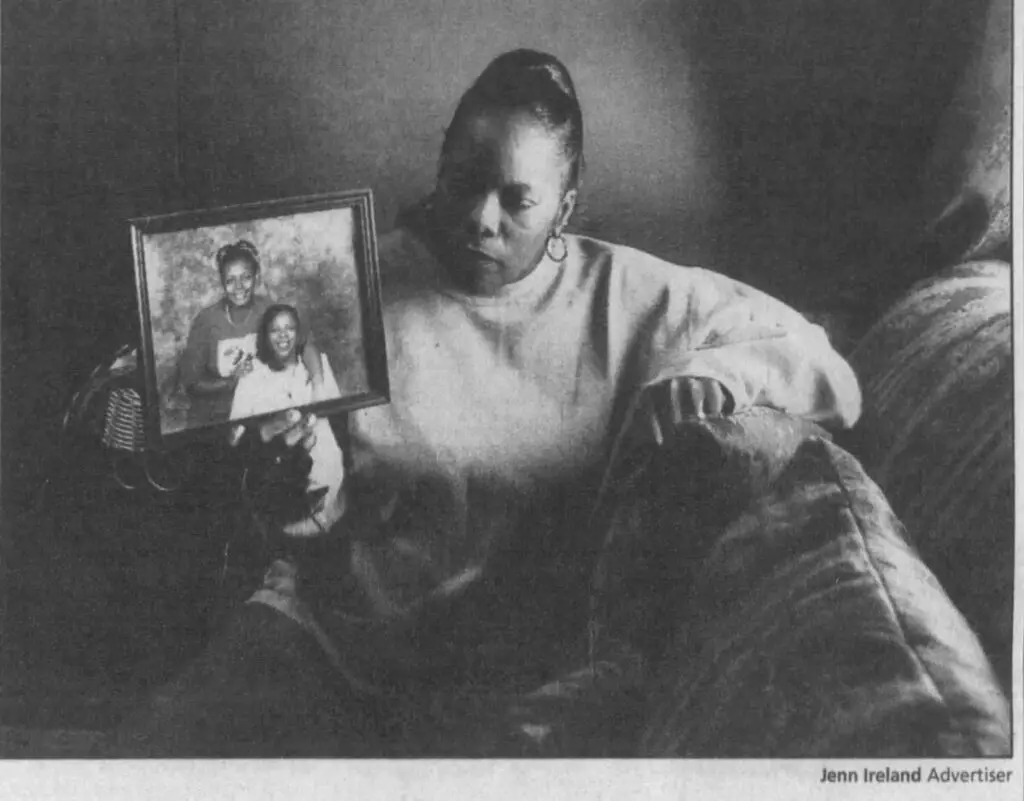 LaQuanta Riley: newspaper photo of her mother holding a picture frame containing a portrait of her and Riley