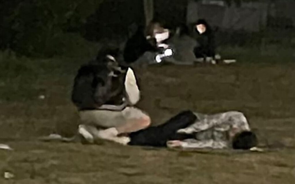 Son Jung-min: photo of Mr. A squatting on ground looking at phone while Son is asleep on ground.
