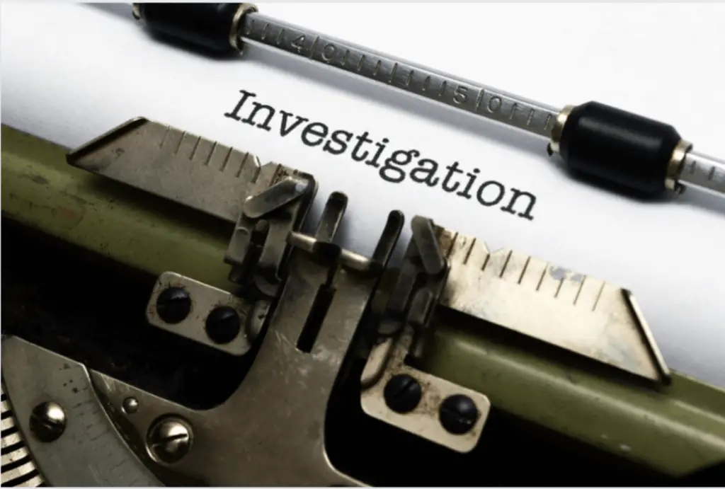 Up close stock photo of a typewriter with "Investigation" typed on white paper