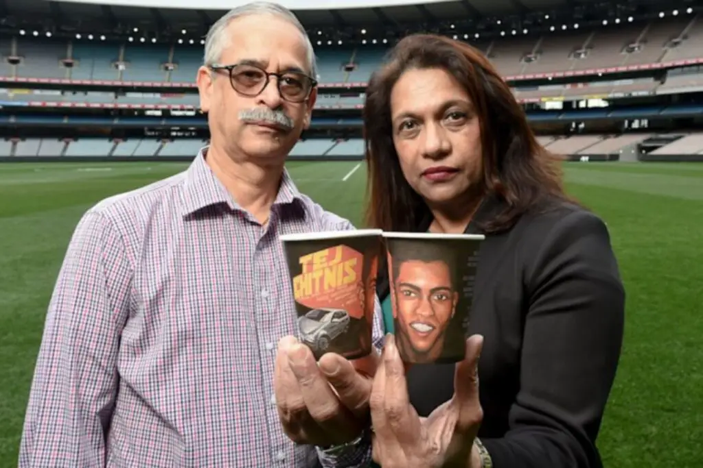 Jayant and Reva Chitnis at the MCG, holding coffee cups with an image of their missing son, Tej and his car. Credit: Justin McManus